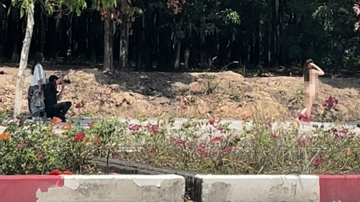 Ông T. cùng nhóm bạn đang chụp ảnh cho người mẫu nữ. (Video được người đi đường quay lại và phát tán mạng xã hội)