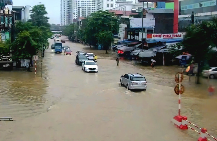 Ô tô bì bòm qua tuyến đường ngập lụt.