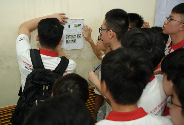 Các đội hội ý tìm giải pháp lập trình cho robot thực hiện nhiệm vụ của đề thi bất ngờ tại trang trại Green Farm và nhà máy Vinamilk.