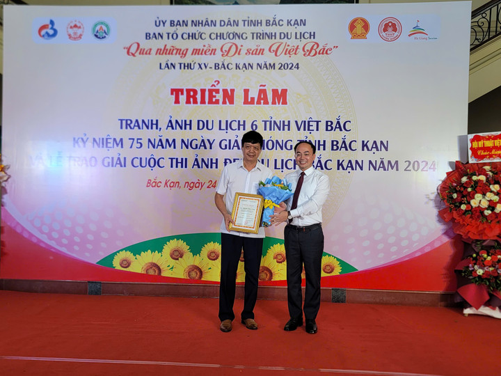 Ông Nguyễn Đăng Bình, Chủ tịch UBND tỉnh Bắc Kạn, trao giải Nhất cho tác phẩm Hội xuân Ba Bể trong triển lãm tranh, ảnh du lịch 6 tỉnh Việt Bắc.