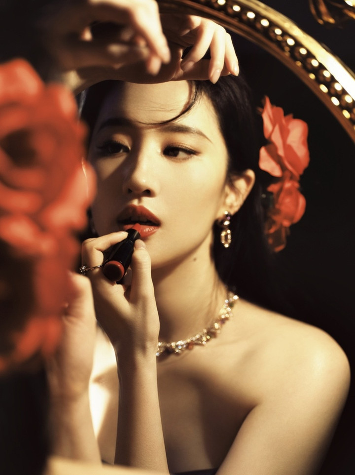 Lưu Diệc Phi diện đầm công chúa khoét cổ rộng, khoe chân dài miên man nằm trên những bông hồng vàng.