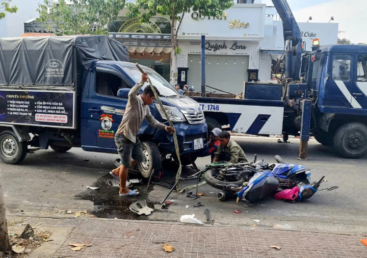 Xe máy nằm dưới bánh xe tải sau va chạm. (Ảnh: Đ.K)