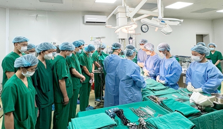 Nhân viên y tế đứng thành hai hàng, họ cùng chắp tay cúi đầu và im lặng.