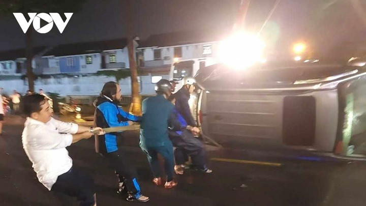 Người dân và lực lượng chức năng hỗ trợ đưa xe ô tô bị cuốn trôi lên bờ.