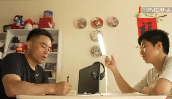 Khoảnh khắc hai cha con cùng ngồi học bài. (Ảnh: Sina)