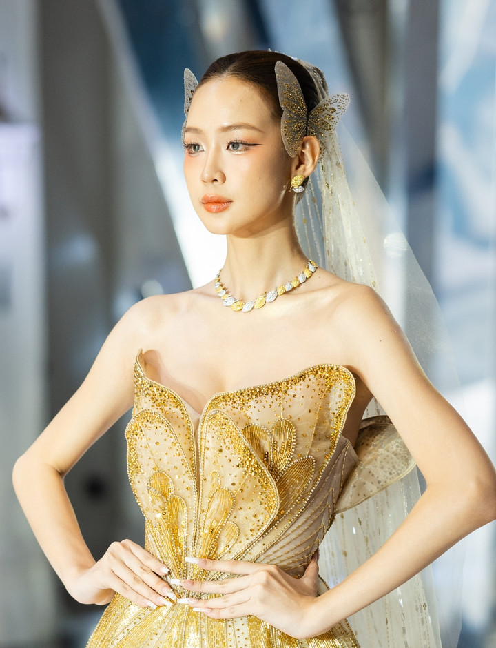 Hoa hậu Lê Nguyễn Bảo Ngọc lộng lẫy trong bộ đầm cánh bướm vàng gold ăn ý chiếc vòng "Dance of Leaves" lấy cảm hứng từ vẻ đẹp của lá cây. Thiết kế đính 1.092 viên đá gồm kim cương lab trắng và kim cương vàng tự nhiên,trị giá 810 triệu đồng, phối ăn ý hoa tai gần 189 triệu đồng.