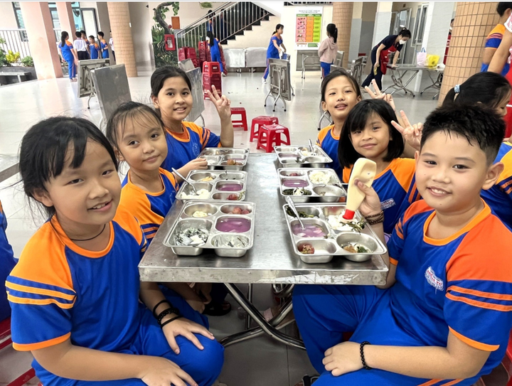 Các em học sinh tiểu học thưởng thức bữa trưa cân bằng dinh dưỡng thuộc dự án Bữa ăn học đường.