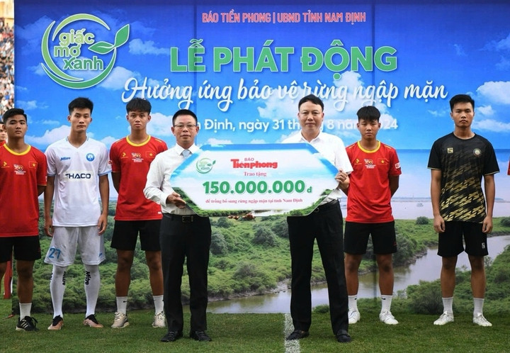 Nhà báo Phùng Công Sưởng - Tổng biên tập Báo Tiền phong, đồng Trưởng ban Tổ chức trận Siêu Cúp bóng đá Quốc gia – Cúp THACO 2023/2024 trao tặng tượng trưng cây trồng trị giá 150 triệu đồng cho ông Mai Quang Tuấn - Chi Cục trưởng Chi cục Kiểm lâm, đại diện Sở Nông nghiệp và Phát triển nông thôn Nam Định.