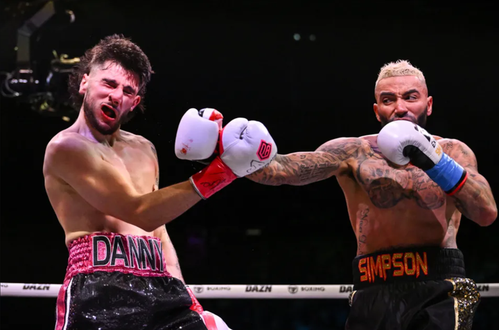 Mặt của Danny Aarons biến dạng sau đòn striking của Danny Simpson.