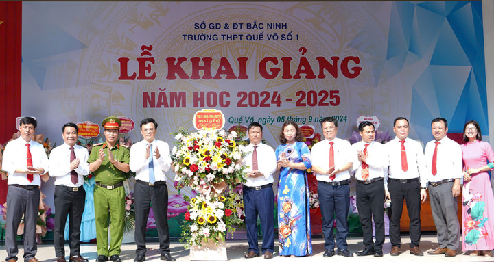 Ông Đặng Văn Tuấn, Chủ tịch UBND thị xã Quế Võ, cùng các đồng chí trong đoàn tặng hoa chúc mừng trường THPT Quế Võ số 1.