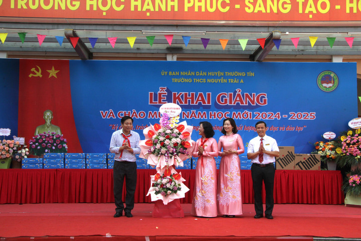 Ông Từ Ngọc Thành, Bí thư Đảng ủy thị trấn Thường Tín tặng hoa chúc mừng nhà trường. (Ảnh: Đỗ Tươi)