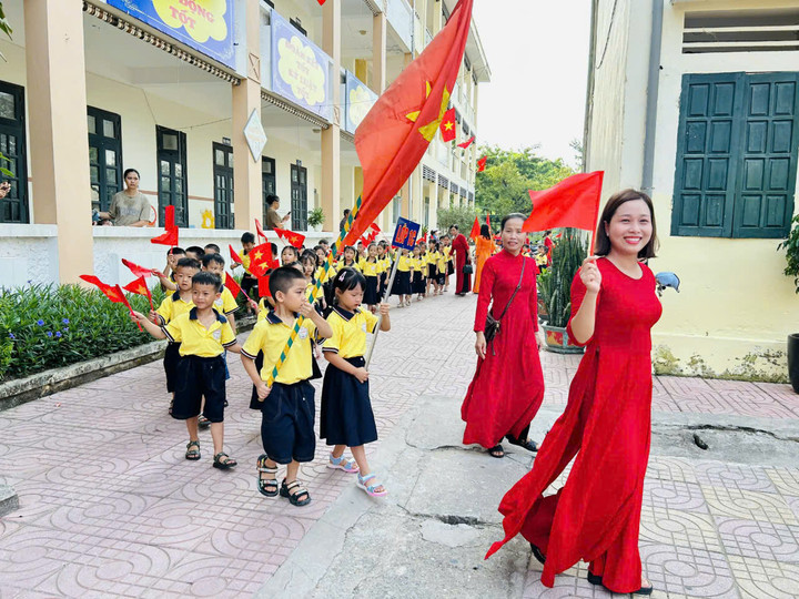 Các em học sinh lớp 1 đang tiến vào lễ đài trong tiếng vỗ tay chào đón của các thầy cô giáo cùng học sinh các khối 2,3,4,5 trường tiểu học Cao Dương.