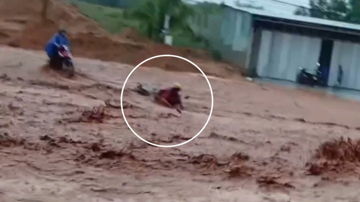 Người phụ nữ bị lũ cát đỏ cuốn trôi (Ảnh cắt từ clip)