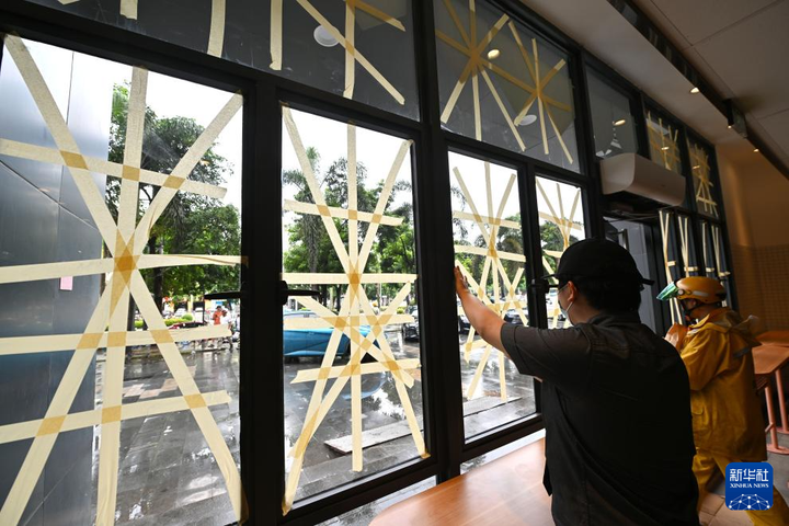 Người dân dán băng dính gia cố cửa kính trước khi bão Yagi đổ bộ ở thành phố Hải Khẩu, Hải Nam, Trung Quốc. (Ảnh: Tân Hoa Xã)