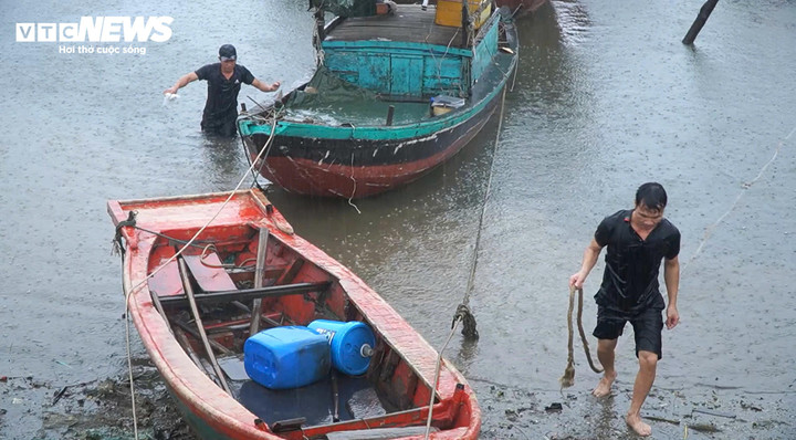 Ngư dân và lực lượng chức năng chằng néo thuyền tại khu neo đậu Cửa Sót (huyện Lộc Hà, Hà Tĩnh).