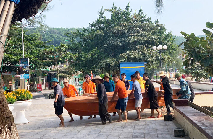 Lực lượng chức năng Đồ Sơn hỗ trợ người dân di chuyển thuyền, bàn ghế... về nơi an toàn.