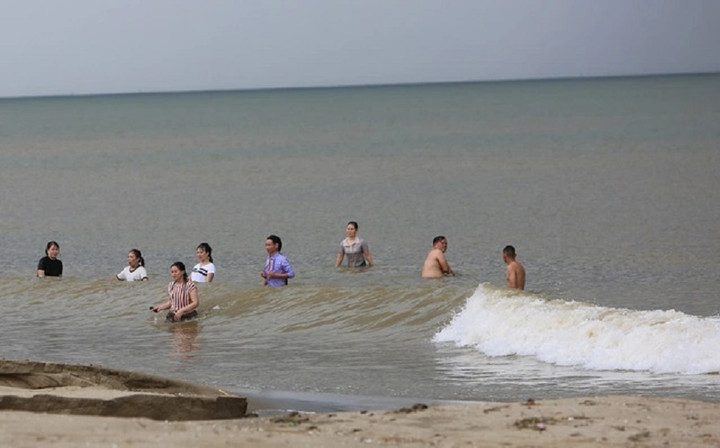Có rất nhiều phụ nữ xuống tắm biển trong khi trời đã bắt đầu mưa, sóng biển dâng cao.