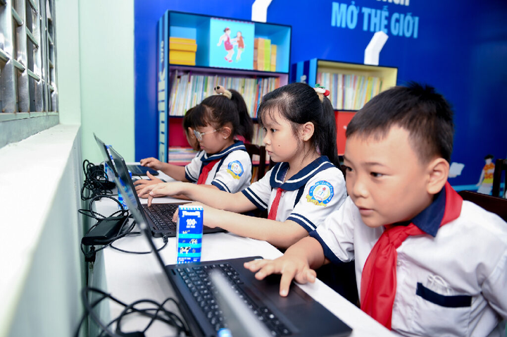 Các em học sinh trải nghiệm các laptop mới trong khu vực tủ sách Vươn cao Việt Nam của Vinamilk.