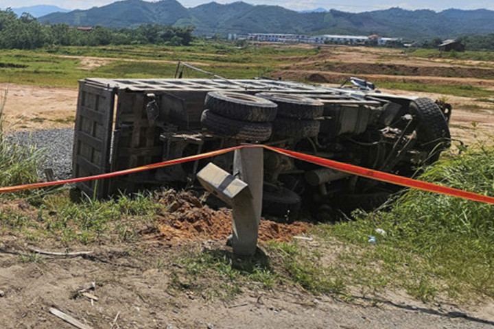 Xe tải bị lật văng ra khỏi đường.