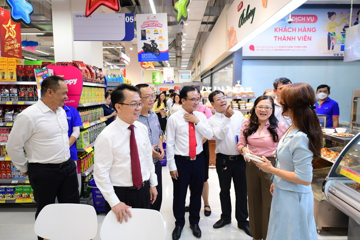 Ông Nguyên Anh Đức - Tổng giám đốc và lãnh đạo Saigon Co.op đưa đại biểu tham quan siêu thị. (Ảnh: Quang Định)