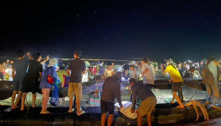 Hàng trăm người địa phương nhặt cá Vàng Áng trong một lồng bè trôi dạt trên bãi biển ở phường Bình Ngọc (Móng Cái, Quảng Ninh).