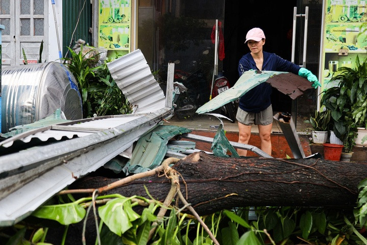 Trước nhiều nhà dân, những thân cây to đổ vắt ngang qua đường, phải nhờ đến thanh niên trong khu phố mang cưa, dao ra để chặt những cành sum suê để vừa chiếc ô tô con lách qua. Nhiều xe lớn hơn phải quay đầu vì không thể di chuyển qua các đoạn đường Cao Thắng - Hà Lầm - Hà Trung.