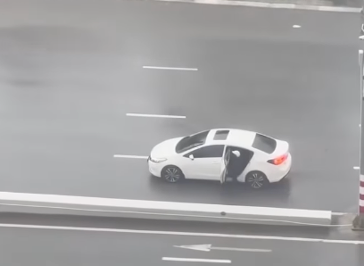 Tài xế bất chấp sức gió mạnh có thể lật cửa vẫn cứu người phụ nữ lên xe. (Ảnh chụp màn hình)