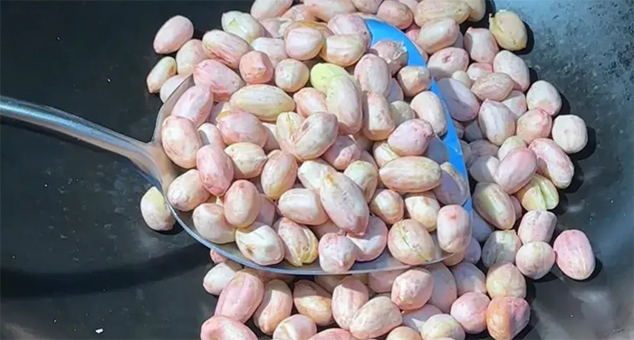 Rang lạc trong chảo lớn và đảo đều tay. (Ảnh: Toutitao)