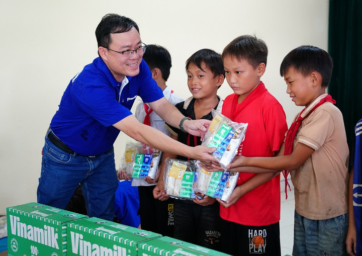Ông Tạ Xuân Tuấn - Giám đốc Kinh doanh Miền Bắc của Vinamilk - trao phần quà cho các bé ở xóm Trung Sơn, xã Quang Sơn, huyện Đồng Hỷ (tỉnh Thái Nguyên) gồm sữa, bánh.
