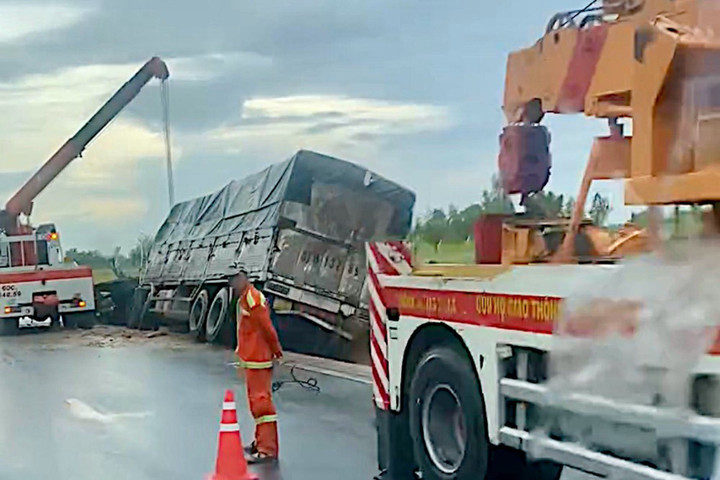 Xe tải lật nghiêng trên rãnh thoát nước ven cao tốc.