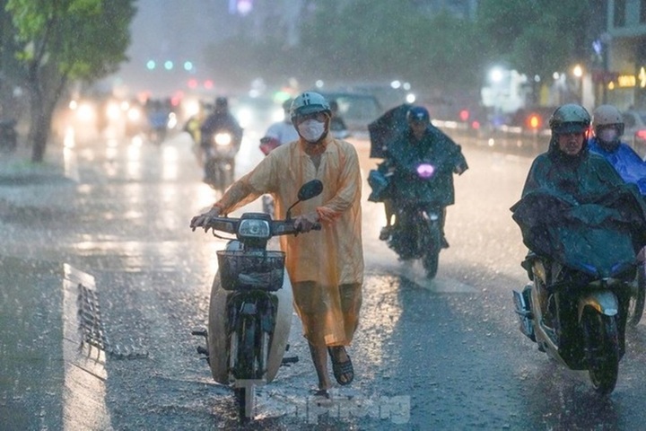 Người dân TPHCM di chuyển trong cơn mưa lớn. (Ảnh: Phạm Nguyễn)