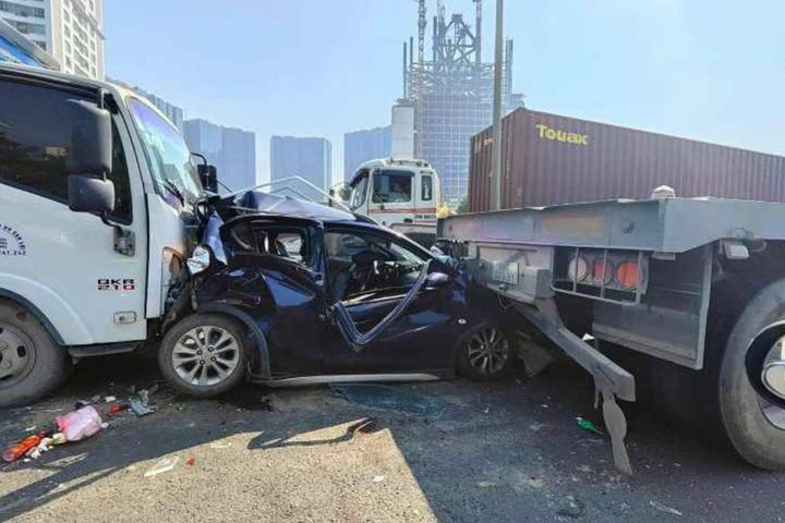 Chiếc ô tô con bị 2 ô tô lớn dồn bẹp rúm sau va chạm.