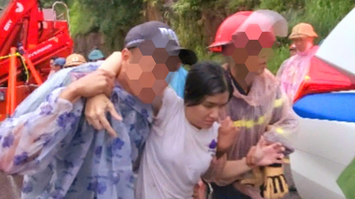 Nguyễn Thu Trang (áo trắng) được lực lượng cứu hộ đưa ra khỏi ô tô.