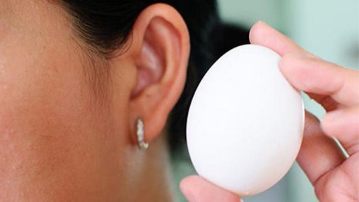 Cầm trứng lên và lắc nhẹ gần tai để nghe - mẹo nhận biết trứng vịt lộn già và trứng vịt lộn non . (Ảnh: Ẩm thực ngon)