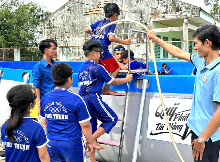 Học sinh được các thầy rửa chân sạch trước khi vào học bơi trong hồ mới.