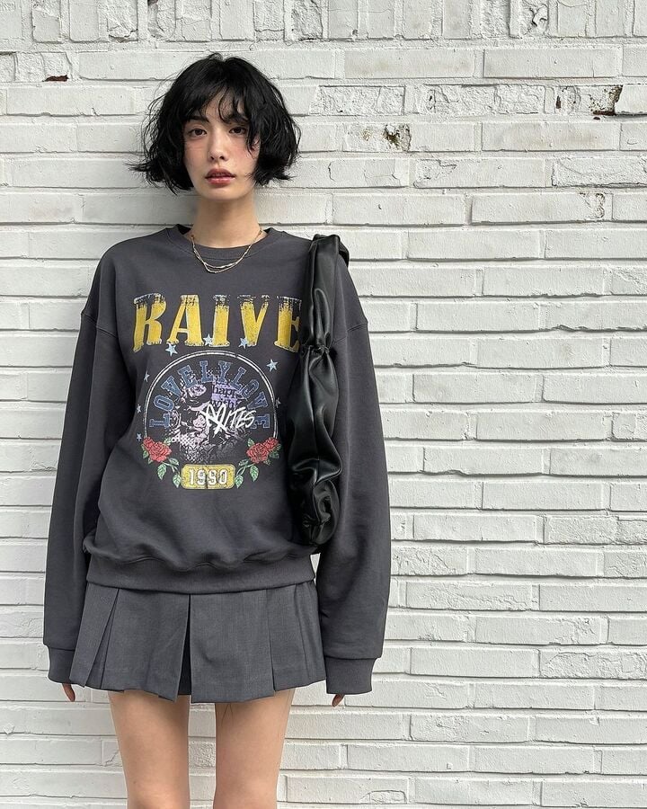 Áo sweater oversized kết hợp chân váy xếp ly mang đến vẻ ngoài năng động.