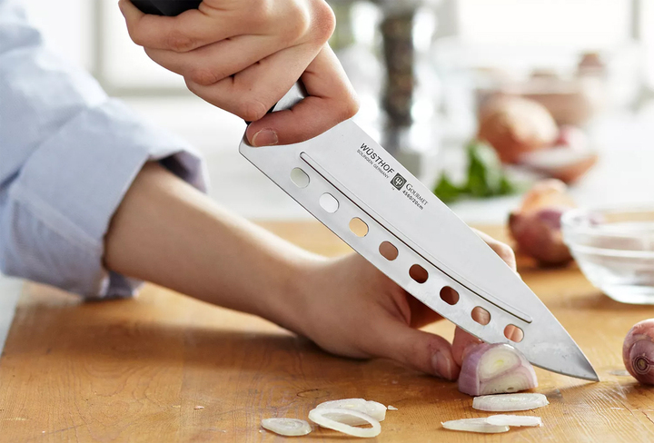 Lỗ tròn trên dao bếp có tác dụng giảm khó khăn khi cắt thực phẩm. (Ảnh: Surlatable)
