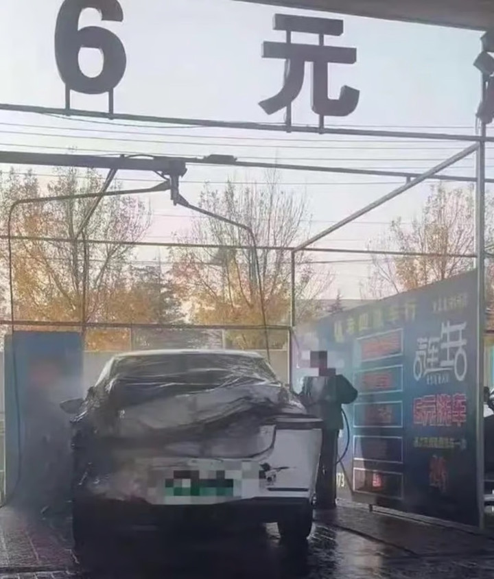 Người phụ nữ vẫn tỉ mỉ làm sạch chiếc xe đã hỏng nghiêm trọng. (Ảnh: Baidu)