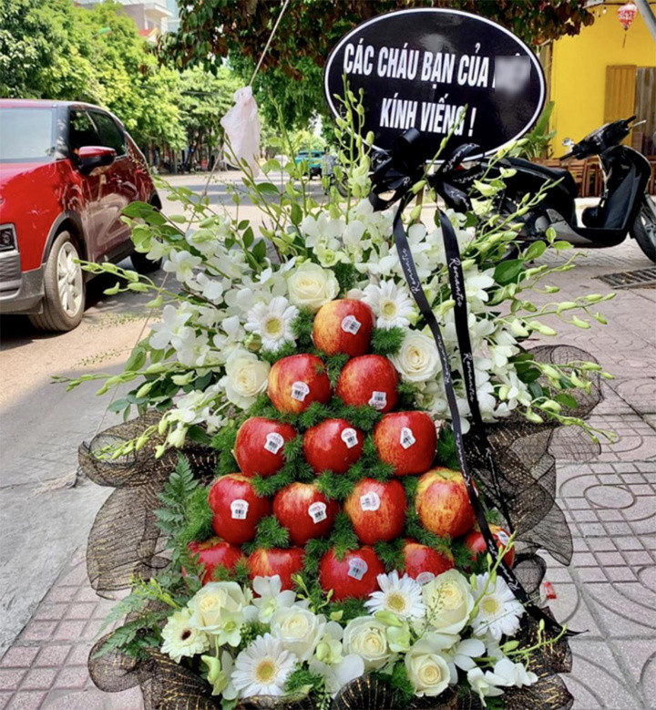 Dân mạng tranh cãi khi viếng đám ma bằng tháp táo đỏ. (Ảnh: FBNV)