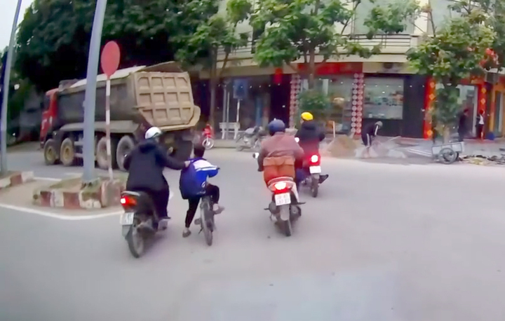 Khoảnh khắc người đàn ông kéo cháu bé đi xe đạp khỏi điểm mù xe tải. (Ảnh cắt từ clip)