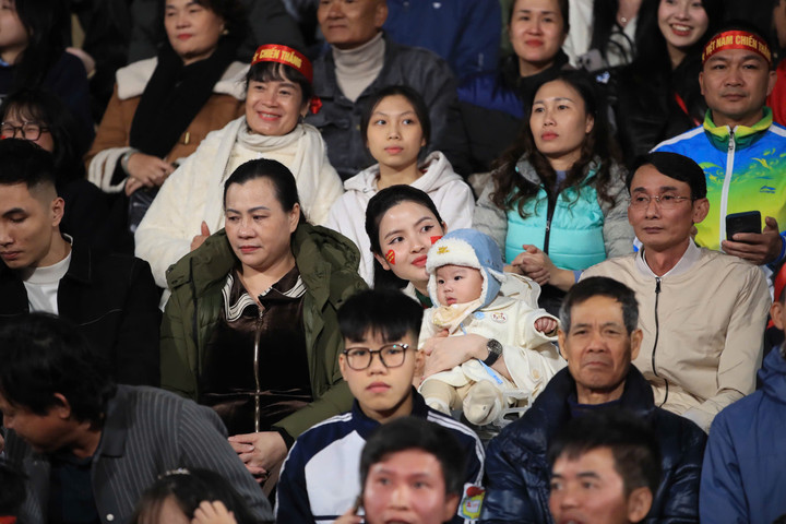 Vợ Quang Hải bế con cổ vũ chồng trên khán đài. Hôm nay Quang Hải là đội trưởng của đội tuyển Việt Nam khi Đỗ Duy Mạnh không góp mặt. (Ảnh: Minh Trang)