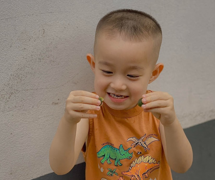 Bé Tony thích thú với những viên kẹo của Happy Vitamin.