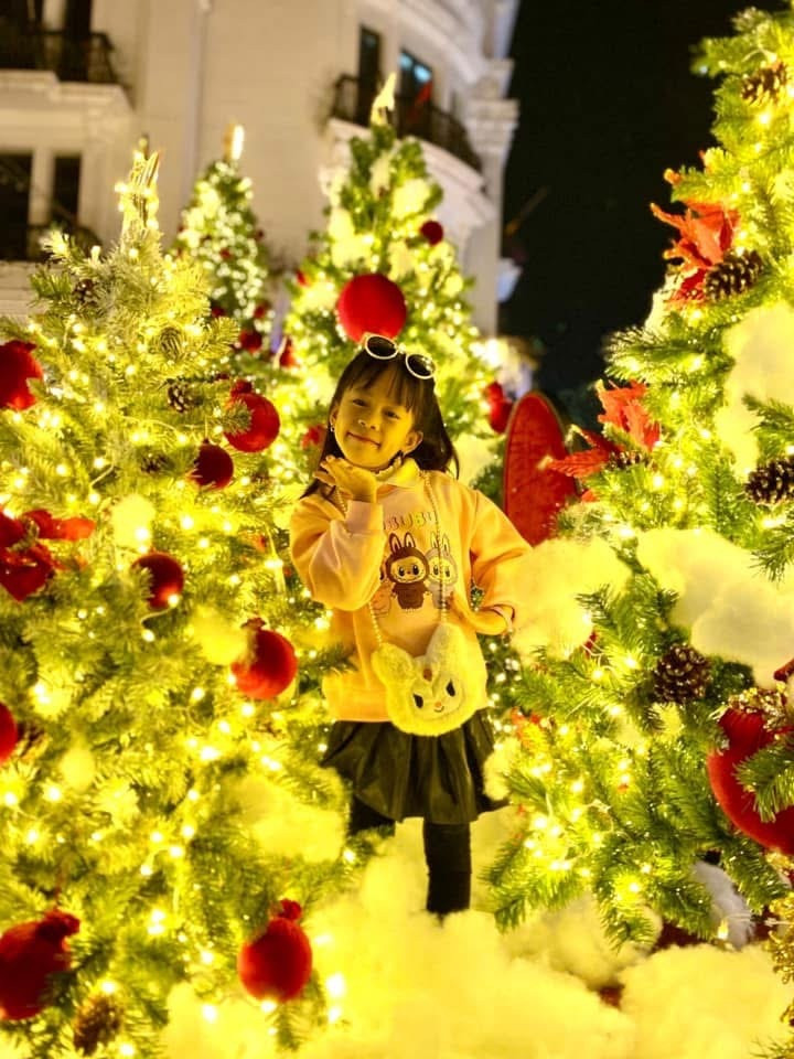 Các em nhỏ tạo dáng bên vườn thông khổng lồ rực rỡ sắc màu.