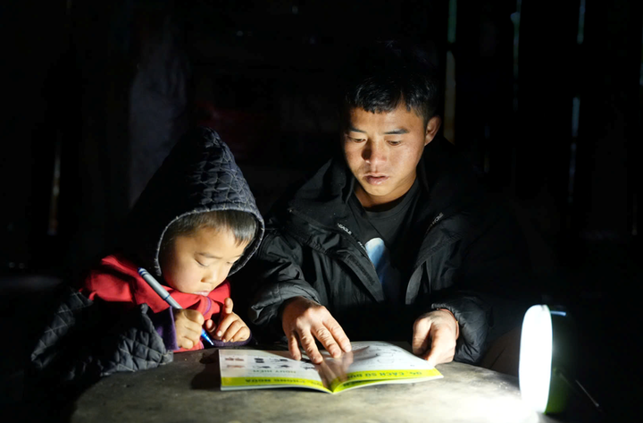 Trẻ em học bài dưới ánh sáng từ đèn năng lượng mặt trời.