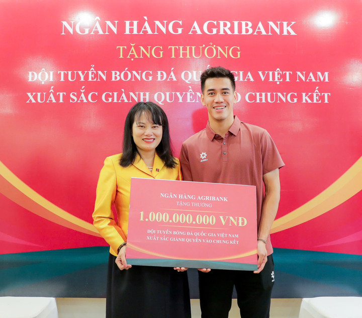 Bà Phùng Thị Bình - Phó Tổng Giám đốc Agribank - trao thưởng 1 tỷ đồng cho đại diện Đội tuyển Bóng đá Quốc gia Việt Nam.