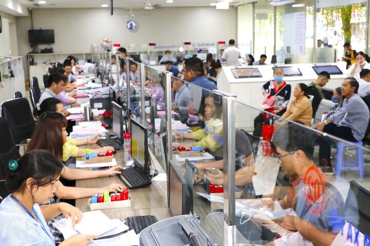 Công chức bộ phận một cửa UBND quận 12 (TP.HCM) giải quyết thủ tục hành chính cho người dân.