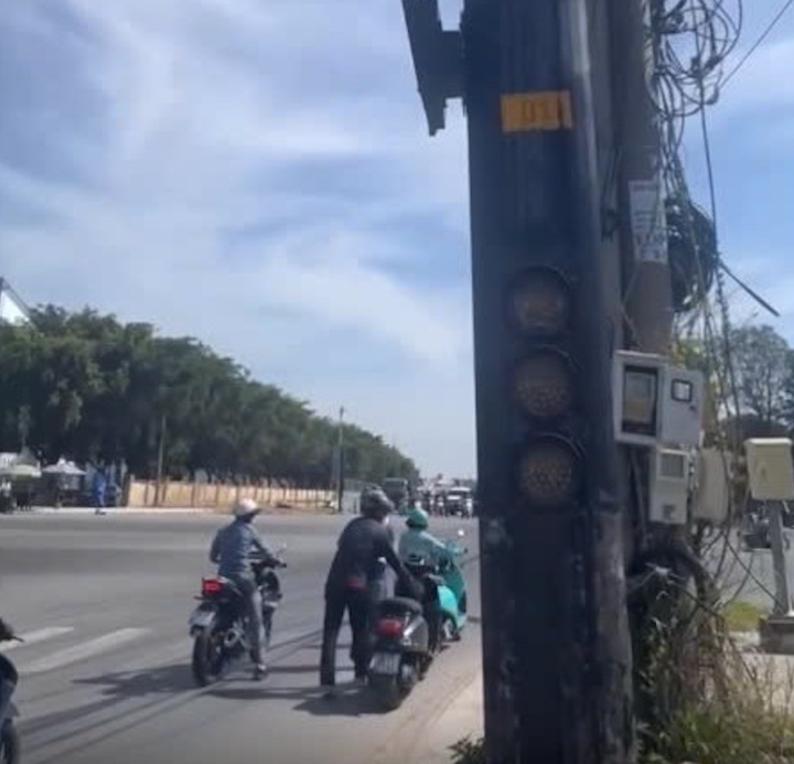 Nhiều người đi xe máy phải dẫn bộ xe vượt qua giao lộ. (Ảnh cắt từ clip).