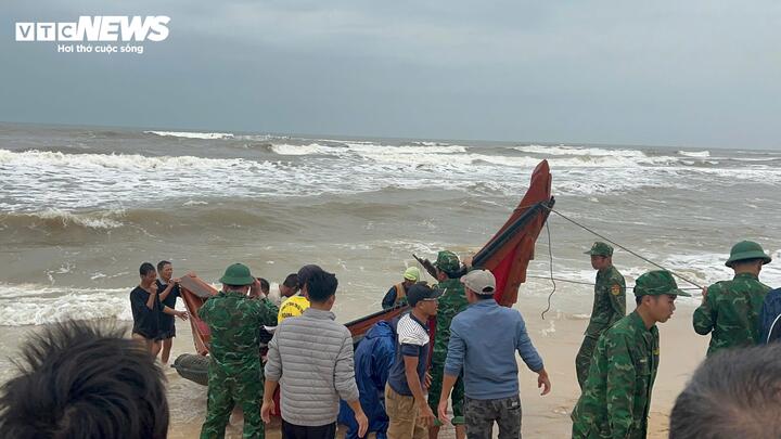 Lực lượng thuộc Đồn Biên phòng Hải An cùng người dân kéo chiếc thuyền cá gặp nạn trên biển vào bờ. (Ảnh: BPCC)