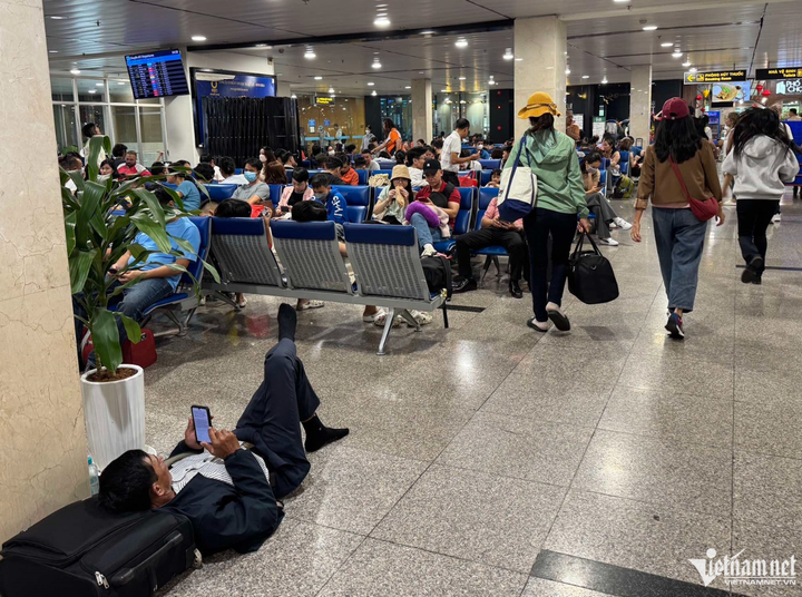 Nhiều khách mệt mỏi nằm giữa sảnh nhà ga do chuyến bay bị delay quá lâu. (Ảnh: L.Mỹ).