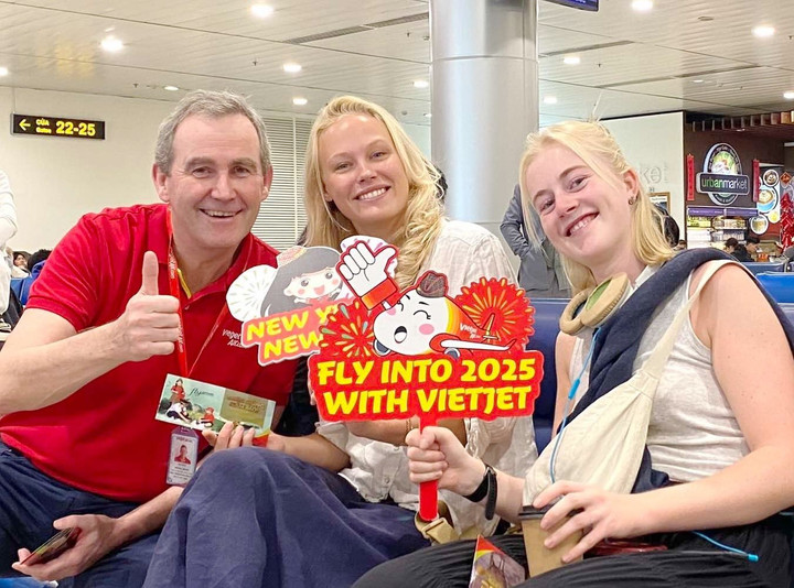 Phó Tổng giám đốc Vietjet Michael Hickey (áo đỏ) chúc mừng năm mới hành khách tại sân bay Tân Sơn Nhất (TP.HCM)